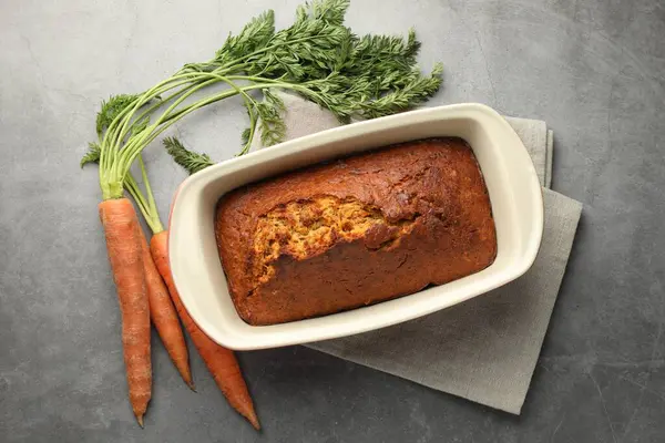 Lezzetli havuçlu kek ve sebzeler gri desenli masada, düz yatıyordu.