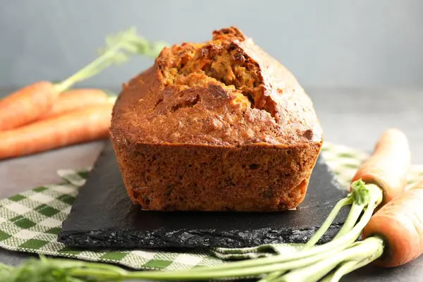 Gri masada lezzetli havuçlu kek ve sebzeler, yakın plan.