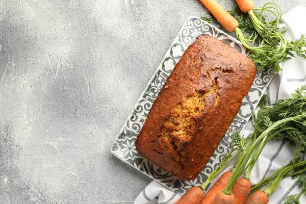 Gri desenli masada havuçlu kek ve sebzeler, düz yatak. Metin için boşluk