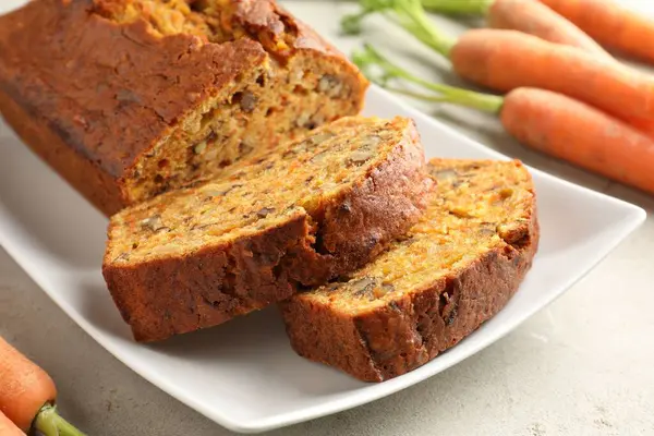 Açık gri masada fındıklı ve sebzeli ev yapımı havuçlu kek, yakın plan.