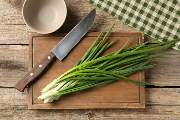 Taze yeşil soğan ve bıçak ahşap masada, üst manzara