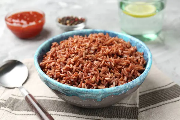 Gri masada servis edilen lezzetli kahverengi pirinç, yakın plan.