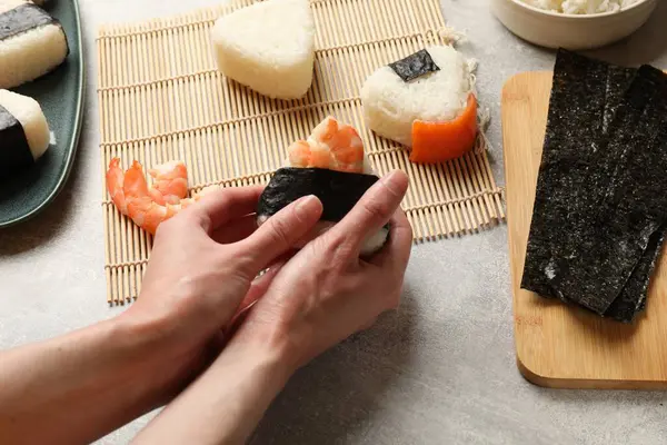 Onigiri yapan kadın (Japon pirinç topları) ışık masasında, yakın plan
