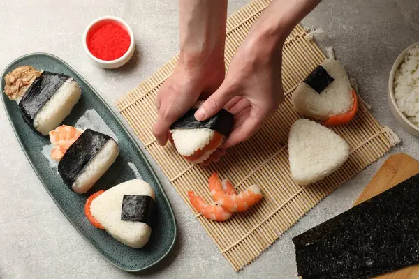 Onigiri yapan kadın (Japon pirinç topları) ışık masasında, yakın plan
