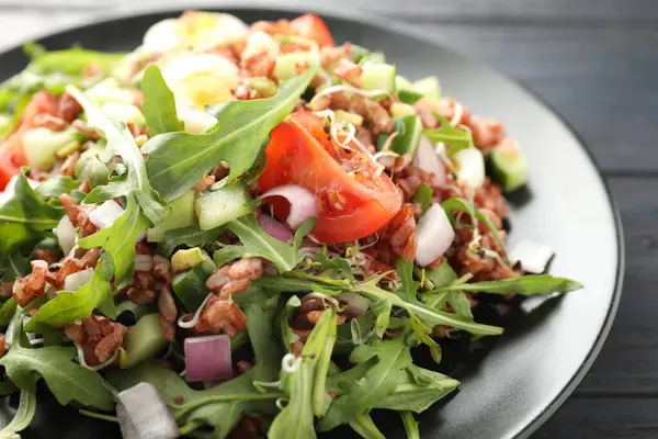Siyah ahşap masada kahverengi pirinçli leziz salata, yakın plan.
