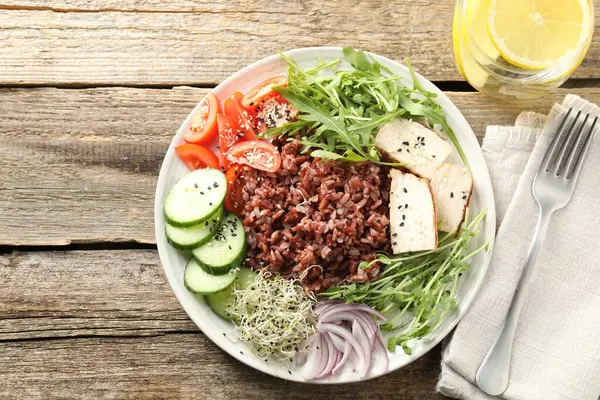 Kahverengi pirinçli nefis salata ve ahşap masada içki, düz yatıyordu.