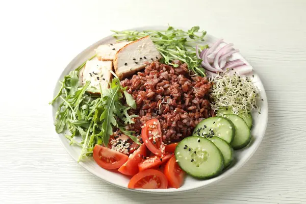 Beyaz ahşap masada kahverengi pirinçli leziz salata, yakın plan.