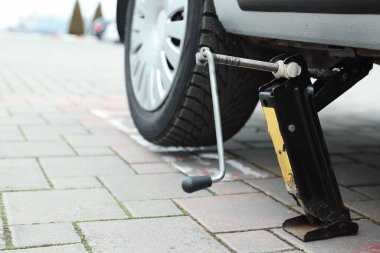 Araba, yol kenarında makas krikosuyla kaldırıldı.