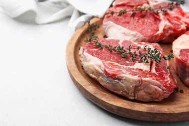 Çiğ et ve baharat parçaları açık gri masada, yakın plan. Metin için boşluk