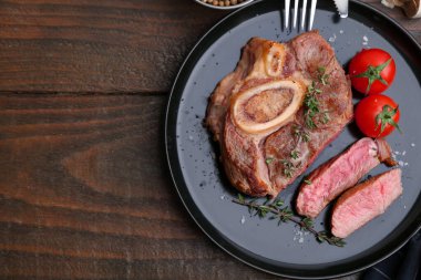 Lezzetli et parçaları, ahşap masada baharatlar ve domatesler, üst manzara. Metin için boşluk