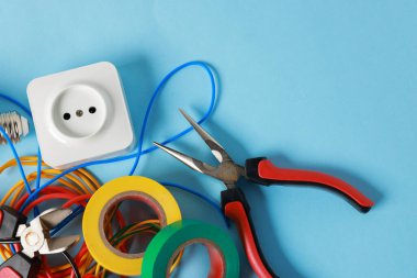 Açık mavi arka planda, düz zeminde farklı elektrikli aletler. Metin için boşluk