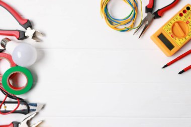 Beyaz ahşap masada farklı elektrikli aletler var. Metin için boşluk