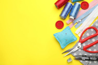 Sarı arka planda farklı dikiş malzemeleri var. Metin için boşluk