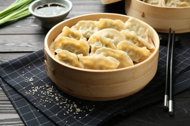 Lezzetli haşlanmış gyoza (hamur tatlısı) siyah ahşap masada servis edilir.