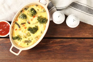 Lezzetli sebze güveci, ahşap masada sos ve baharatlar, düz uzanma