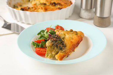 Lezzetli sebze güveci ve beyaz ahşap masada salata, yakın plan.