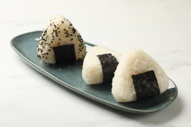Pirinç topları (onigiri) ışık masasında, yakın plan. Geleneksel Japon yemeği