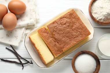 Lezzetli Japon Castella sünger keki ve beyaz ahşap masa üzerindeki malzemeler.