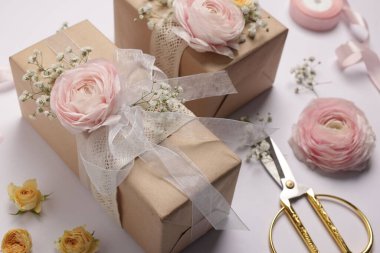 Çiçekçi. Beyaz arkaplanda kutular, çiçekler, kurdele ve makas, yakın plan