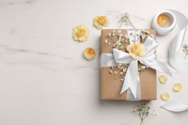 Çiçekçi. Kutu, çiçekler ve kurdele beyaz mermer masada, düz yerde. Metin için boşluk