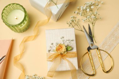 Çiçekçi. Bej arka planda kutular, çiçekler, kurdele ve makas, düz uzanma