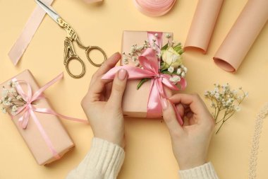 Çiçek kutuları, çiçekler, makas ve bej arka planda kurdele olan çiçekçi.