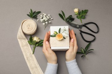 Çiçek kutusu, çiçek, makas ve kurdeleli gri arka plan, üst manzara