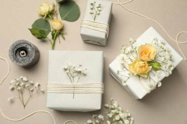 Çiçekçi. Kutular, çiçekler ve yanan mum açık gri arka planda, düz yatıyordu