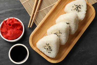 Lezzetli onigiri (Japon pirinç topları) siyah masada servis edilir.