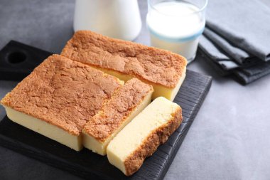 Lezzetli Japon Castella kek ve süt gri masada, yakın plan. Metin için boşluk
