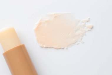 Dudak kremi ve örnek beyaz arka planda, üst görünümde.