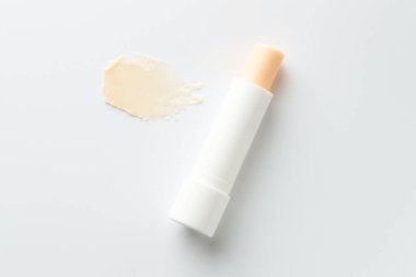 Dudak kremi ve örnek beyaz arka planda, üst görünümde.