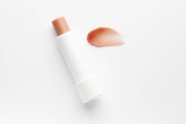 Dudak kremi ve örnek beyaz arka planda, üst görünümde.