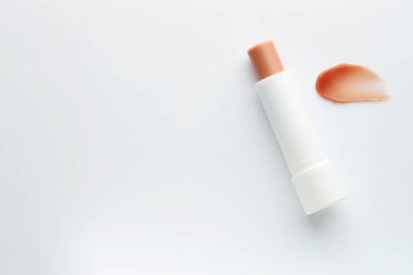 Beyaz arka planda dudak kremi ve örnek, üst manzara. Metin için boşluk