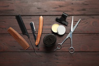 Birçok farklı berber aletleri ahşap masada, düz yatıyordu.