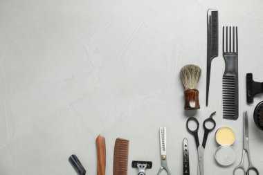 Many different barber's tools on light grey table, flat lay. Space for text
