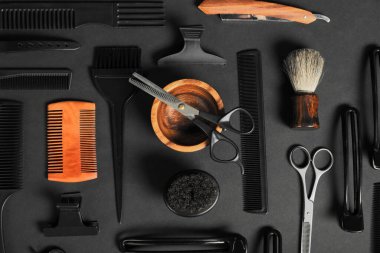 Siyah masanın üzerinde bir sürü farklı berber aleti vardı.