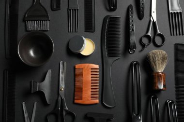 Siyah masanın üzerinde bir sürü farklı berber aleti vardı.