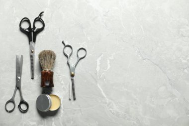 Many different barber's tools on light grey table, flat lay. Space for text