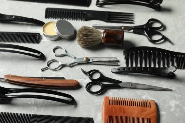 Açık gri masada birçok farklı berber aletleri var.