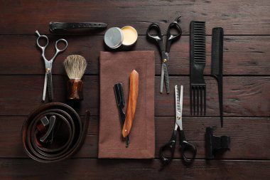 Birçok farklı berber aletleri ahşap masada, düz yatıyordu.