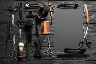 Birçok farklı berber aletinden yapılmış çerçeve siyah ahşap masa üzerinde, düz yatıyordu. Metin için boşluk
