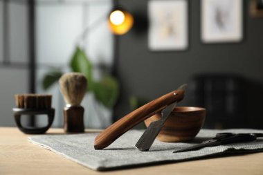 Berber dükkanında, açık ahşap masanın üzerinde birçok farklı berber aleti var.