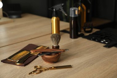 Berber dükkanında, açık ahşap masada birçok farklı berber aletleri var.