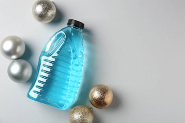 Plastik şişede antifriz ve gri arka planda mücevherler. Metin için boşluk