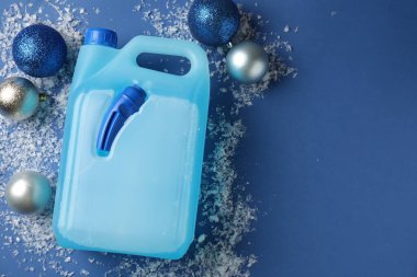 Plastik kapta antifriz, takılar ve mavi arka planda buz, düz bir zemin. Metin için boşluk