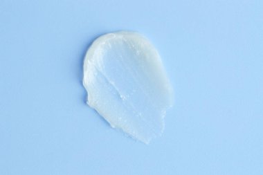 Açık mavi arkaplanda nemlendirici dudak kremi, üst görünüm