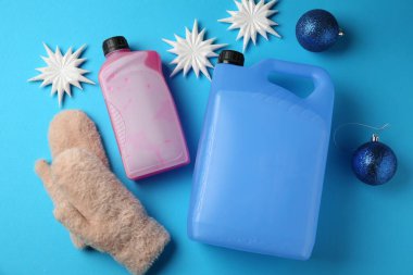 Açık mavi arka planda antifriz, eldivenler ve kış dekoru, düz yatıyordu.