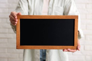 Elinde boş, küçük bir tahta tutan kadın, yakın plan.