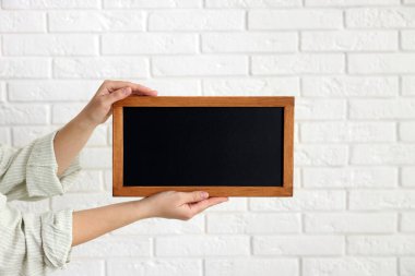 Elinde boş, küçük bir tahta tutan kadın, yakın plan.